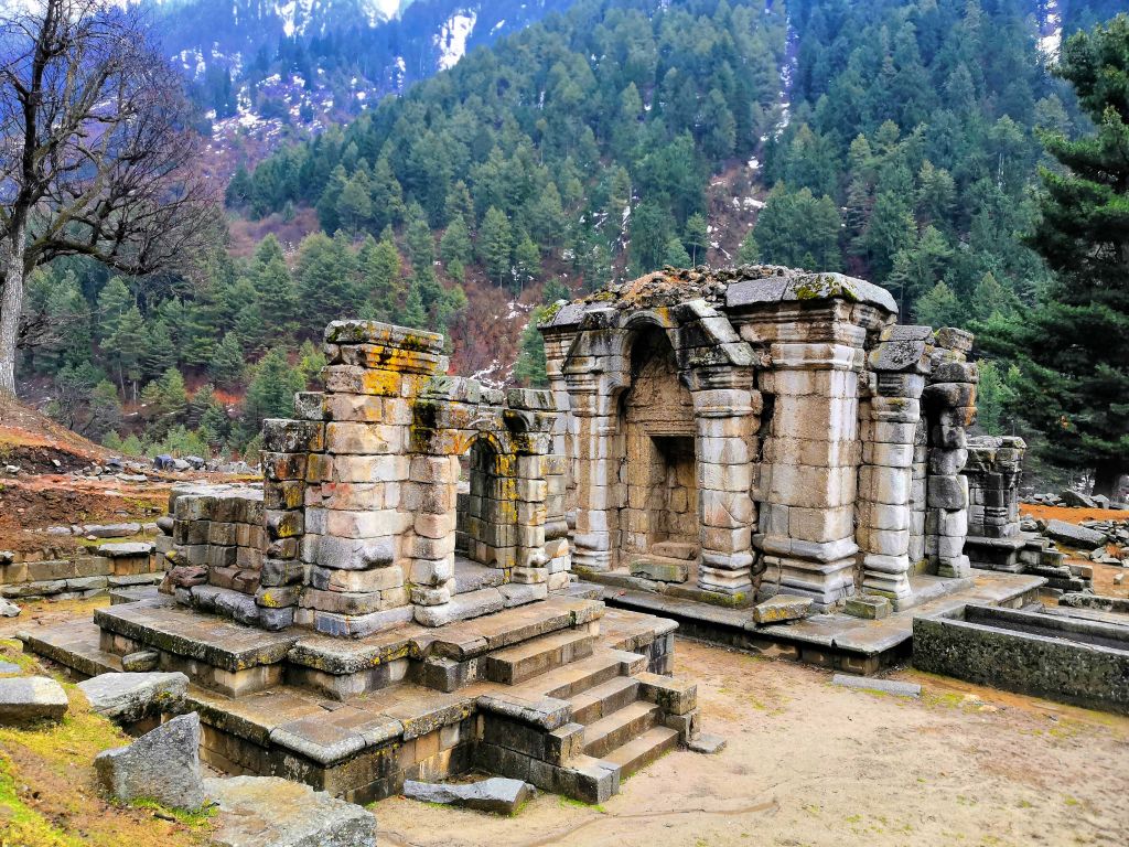 Ancient temple ruins with mountain in background in kashmir tour by Eka experiences