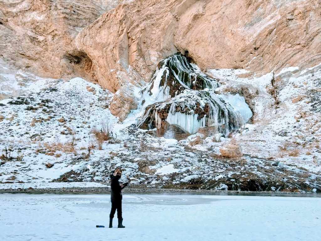 Man standing near Frozen Waterfall Chadar Trek Ladakh India_Eka Experiences